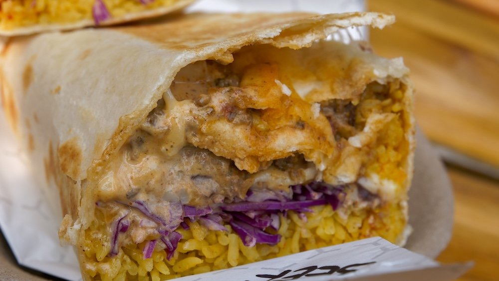Fernie, British Columbia post-hike food close-up featuring the Beefy Boy burrito from Luchadoro, packed with seasoned beef, rice, sauce, and crispy textures, a satisfying summer-only reward after hiking trails around Fernie.
