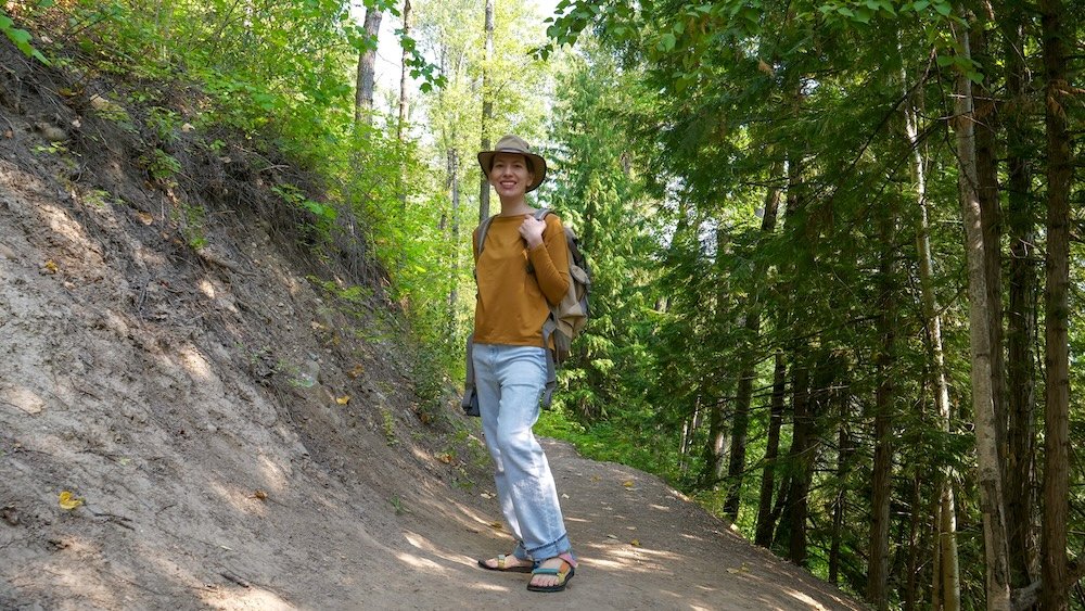 Fernie, British Columbia forest hiking on the Fairy Creek Falls trail with Audrey Bergner of That Backpacker enjoying a shaded woodland path, gentle elevation, and lush greenery on one of Fernie’s most popular easy waterfall hikes.
