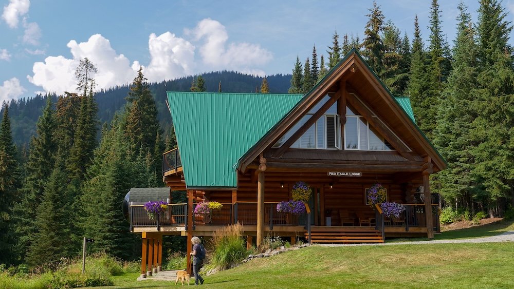 Fernie, British Columbia mountain lodge scenery at Red Eagle Lodge within Island Lake Lodge, featuring classic log architecture surrounded by forested slopes, reflecting the secluded, upscale backcountry atmosphere that defines this iconic Fernie experience.
