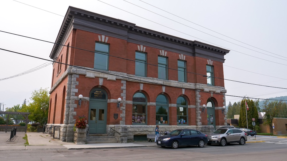 Fernie Heritage Library historic building The Fernie Heritage Library in downtown Fernie, British Columbia, housed in a red-brick historic building with arched windows and stone detailing, photographed along a walkable streetscape that reflects Fernie’s post-fire rebuilding era and long-standing civic pride.