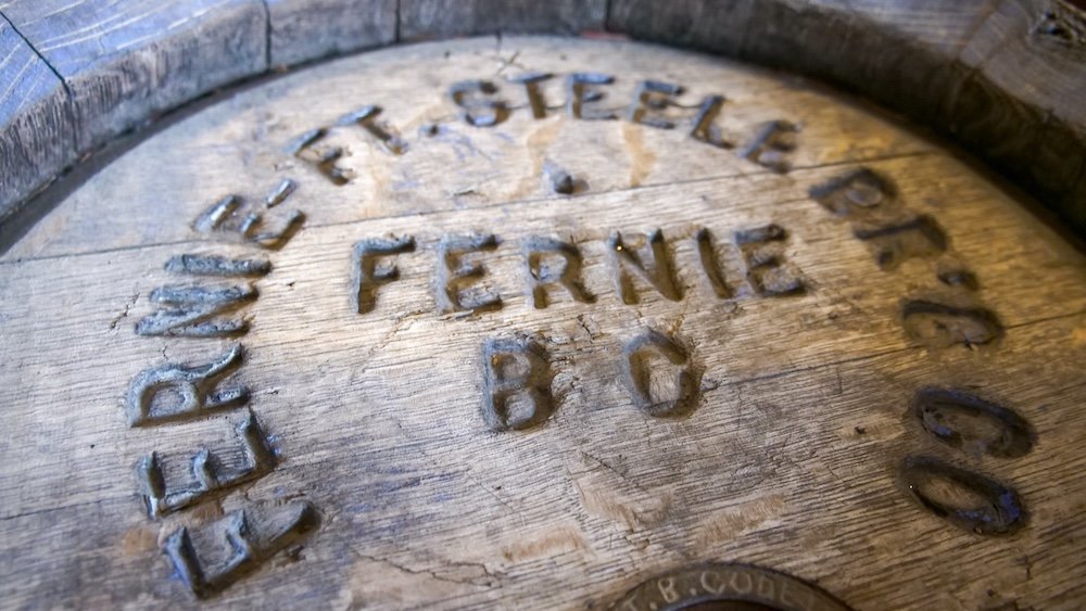 Historic Fernie brewery barrel lid display Close-up of a stamped wooden barrel lid reading "F.T. Steele Brewing Co, Fernie, B.C." inside the Fernie Museum, reflecting early industry and craftsmanship tied to Fernie’s mining-era economy and small-town commercial history.
