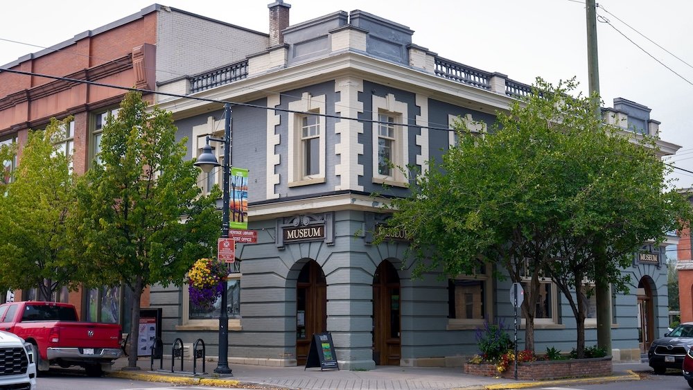The Fernie Museum exterior anchors a downtown street corner in Fernie, British Columbia, with its restored early-20th-century façade, arched entrances, and heritage details, serving as the starting point for the self-guided heritage walking tour through Fernie’s historic core.
