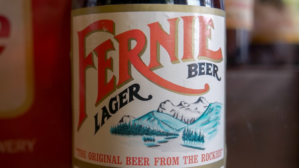 Vintage Fernie Lager beer label in Fernie Museum Close-up of a vintage Fernie Lager beer label displayed inside the Fernie Museum in Fernie, British Columbia, featuring classic typography and Rocky Mountain artwork that reflects the town’s brewing history and ties to working-class mining culture and early local industry.