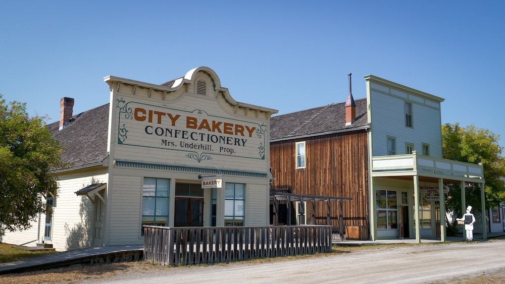 Fort Steele, BC historic streetscape featuring original wooden buildings like the City Bakery and storefronts, showcasing why this restored heritage town makes an easy and rewarding day trip from Cranbrook for history lovers and families.
