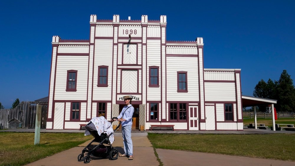 Fort Steele, British Columbia, featuring preserved wooden heritage buildings as Audrey Bergner strolls with baby Aurelia in a stroller, highlighting Fort Steele’s gold rush history, open-air museum atmosphere, and why this living heritage town makes a relaxed, educational, and family-friendly day trip from Fernie.