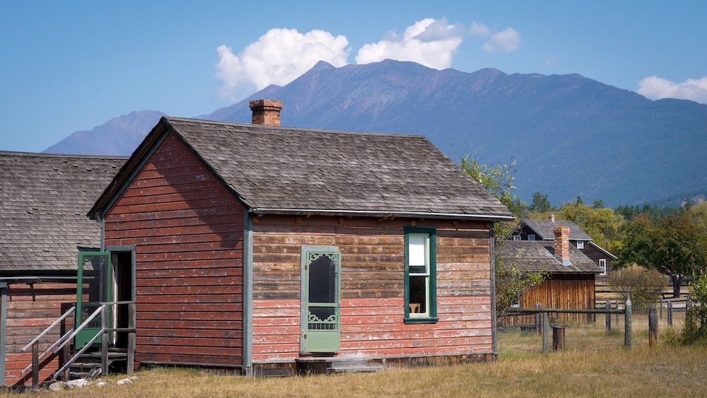 Fort Steele Heritage Town near Cranbrook, British Columbia, showing preserved wooden historic buildings set against the Rocky Mountain backdrop, capturing the open-air museum atmosphere we experienced during a daytime visit before heading to St. Eugene.