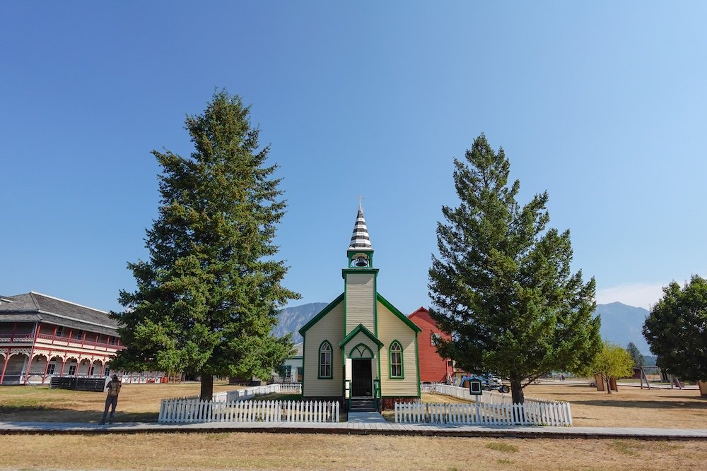 Fort Steele Heritage Town near Cranbrook, British Columbia, featuring historic wooden buildings and open grounds set against mountain scenery, highlighting this well-preserved heritage site as a rewarding and educational add-on day trip for visitors based in Cranbrook.
