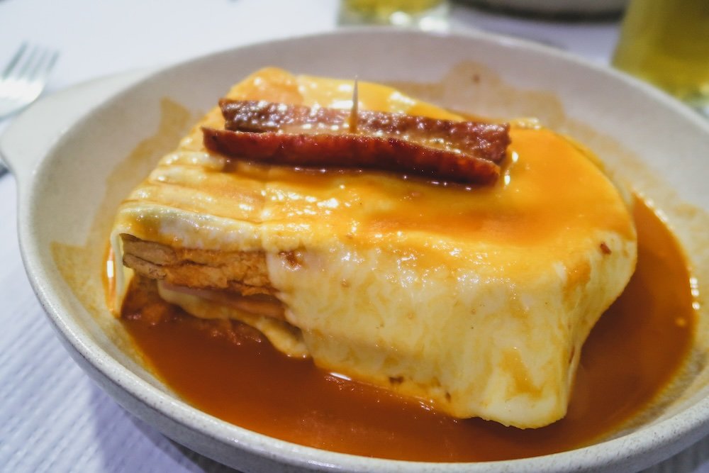 Francesinha monstrous sandwich with ham, sausage, steak, cheese, and a beer-based sauce as Porto’s signature dish in Portugal