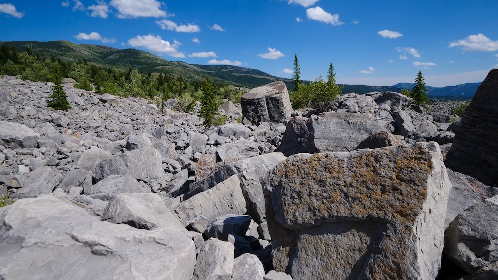 Frank Slide in the Crowsnest Pass, Alberta, showing massive limestone boulders scattered across the valley floor beneath open mountain skies, a dramatic geological landmark often visited as a half-day or full-day road trip from Fernie, British Columbia.