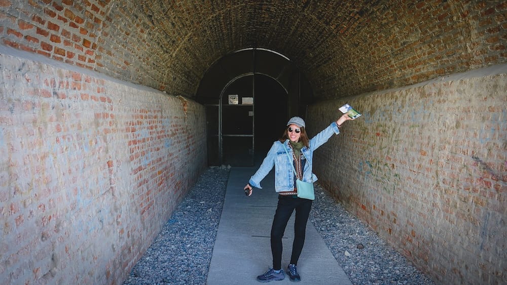 Gaiman Patagonia Audrey Bergner standing inside the 1914 railway tunnel built through a hillside after locals rejected tracks in the town center highlighting this unique historic site visitors can walk through today