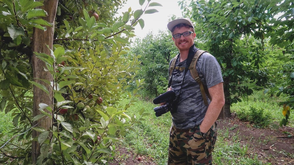 Gaiman Patagonia Samuel Jeffery standing in an apple orchard with trees and greenery in the Chubut Valley highlighting one of the quieter local experiences beyond tea houses in this small Welsh town setting
