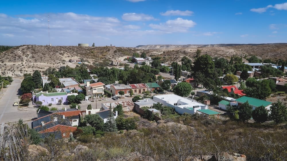 Gaiman town view in Patagonia from elevated vantage point showing quiet settlement surrounded by open steppe, illustrating how even sheltered-looking towns exist within the broader system of strong Patagonian winds shaping daily life