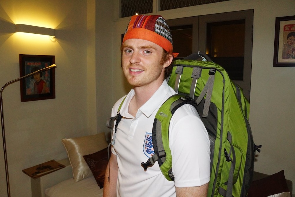 George Town, Penang, Malaysia — Nomadic Samuel wearing a backpack in a guesthouse room, marking the very beginning of his backpacking journey where NomadicSamuel.com was first imagined and launched.