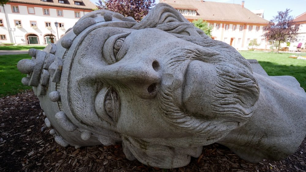 Giant sculpture head slanted on the ground at Sankt Blasien a small town in the Black Forest, Germany