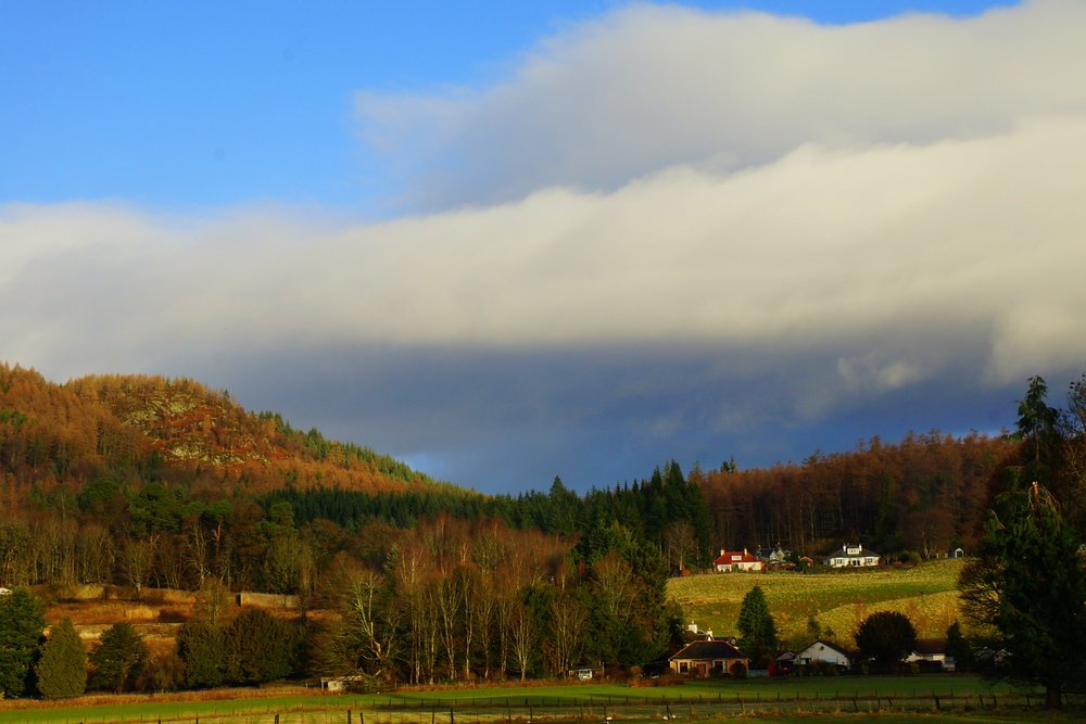 Gorgeous scenery from the Scottish Highlands featuring autumn colours and fluffy white clouds 