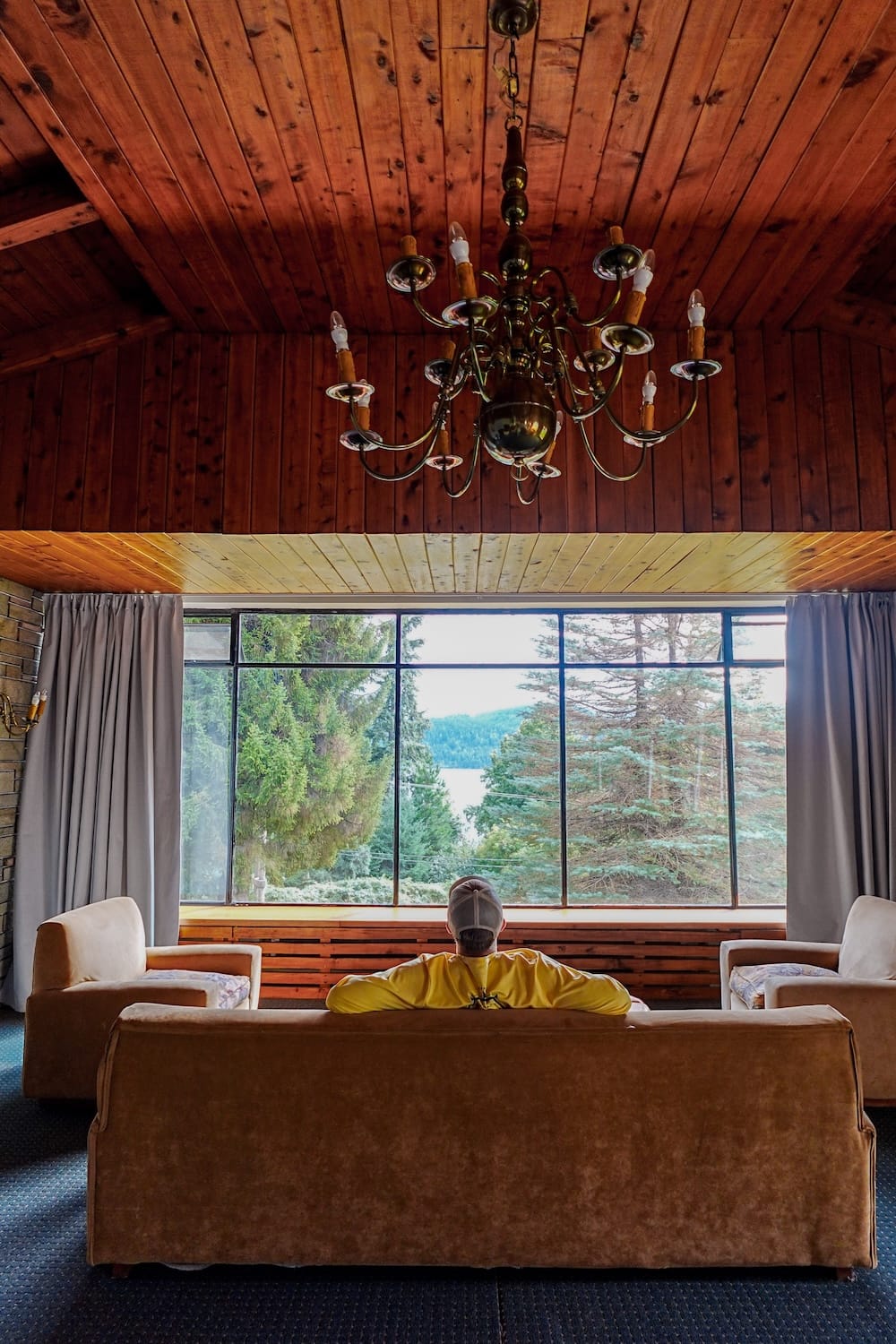 Samuel Jeffery at Gran Hotel Panamericano near Bariloche, Río Negro, Patagonia, Argentina Samuel Jeffery sits in the wood-panelled lounge of Gran Hotel Panamericano near Bariloche, looking through large windows toward trees and Nahuel Huapi Lake in Río Negro, Patagonia, Argentina.