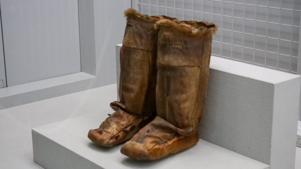 Pair of tall traditional fur-lined boots displayed inside the Hakodate City Museum of Northern Peoples in Hakodate, Hokkaido, Japan, showing cold-weather clothing from the museum collection.