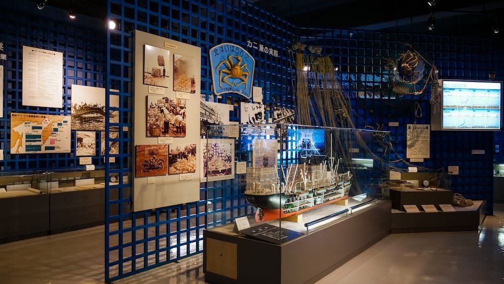 Fishing-history exhibits inside the Hakodate City Northern Pacific Fishery’s Document Museum in Hakodate, Hokkaido, Japan, including a detailed model vessel, archival photographs, nets and maritime displays.