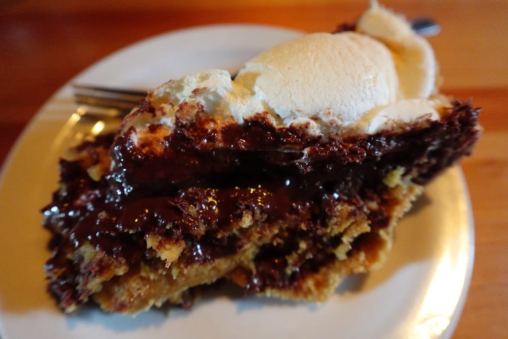 Postre s’more bake en Halfway Lodge durante una travesía a caballo de Banff Trail Riders en el Parque Nacional Banff Un s’more bake abundante con chocolate y marshmallow derretido servido en un plato blanco en Halfway Lodge, Parque Nacional Banff, Alberta, Canadá, durante una travesía a caballo de Banff Trail Riders.
