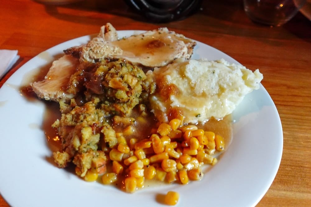 Cena de pavo con gravy y stuffing en Halfway Lodge durante una travesía a caballo de Banff Trail Riders Un plato abundante de pavo con gravy, stuffing, puré de papas y maíz servido en Halfway Lodge, Parque Nacional Banff, Alberta, Canadá, durante una travesía a caballo de Banff Trail Riders.