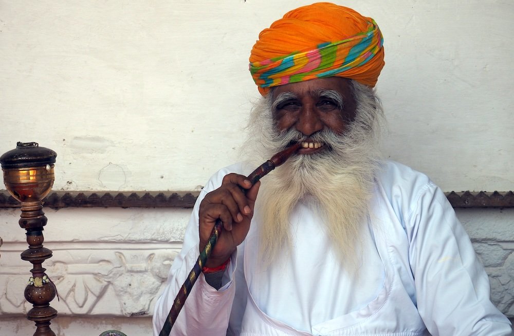 Happy Indian man smoking a pipe in Jodhpur, India 