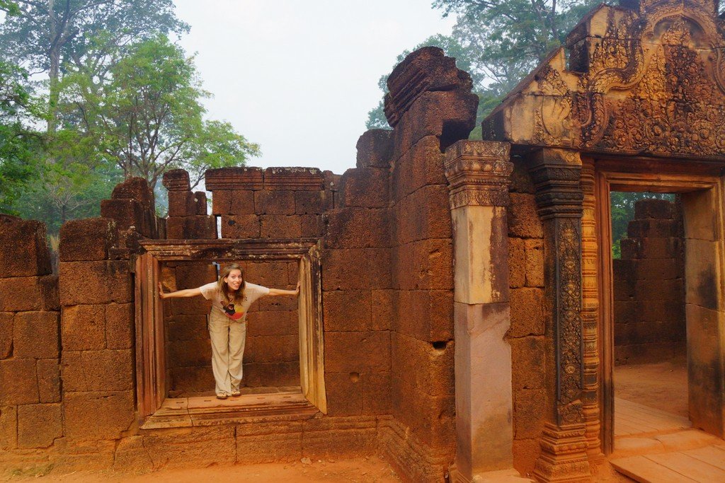 Here That Backpacker Audrey Bergner is posing in one of the windows at Banteay Srei in Cambodia 