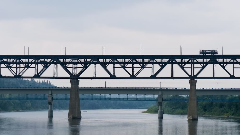 Edmonton’s High Level Bridge Streetcar travels across the upper deck of the High Level Bridge above the North Saskatchewan River, with another bridge and the river valley visible below in Edmonton, Alberta, Canada.