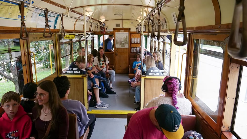 Passenger interior of Edmonton’s High Level Bridge Streetcar heritage tram in Alberta, Canada Interior of Edmonton’s High Level Bridge Streetcar in Alberta, Canada, with passengers seated inside the wood-trimmed heritage tram beneath rows of hanging hand straps and vintage-style fixtures.