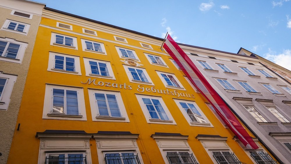 Iconic yellow building Mozarts house with flag in Salzburg, Austria 