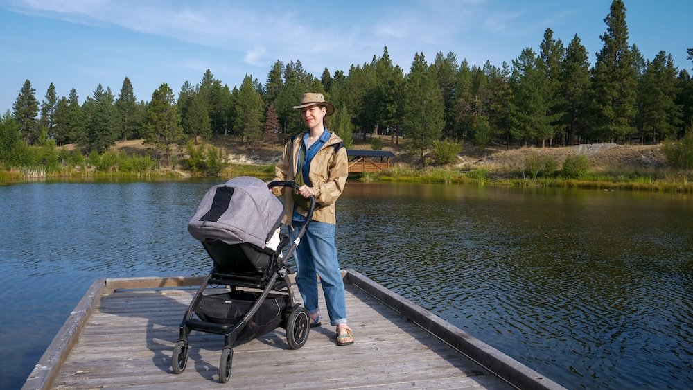 Idlewild Park in Cranbrook, British Columbia, with calm lake views and pine forest scenery as Audrey Bergner strolls along the dock with baby Aurelia, showing how easy, relaxed, and family-friendly travel feels at this peaceful local park.
