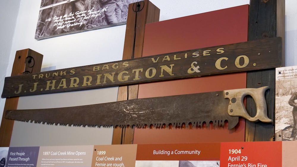 Historic artifacts inside the Fernie Museum Interior view inside the Fernie Museum showing historic tools, signage, and artifacts mounted above timeline panels, highlighting Fernie’s early industries, community building, and everyday life during the mining era in British Columbia.