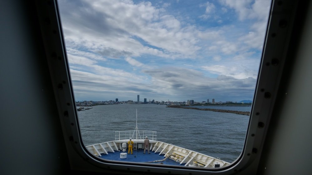 Japanese ferry views out of the window with workers in Japan on the deck