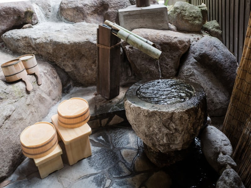 Japanese onsen with bamboo water system delivery and bathing bowls in Japan 