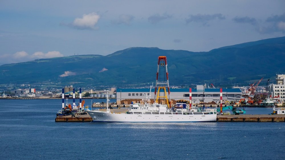 Japanese ship coastal views with mountain backdrop in Hakodate, Japan 