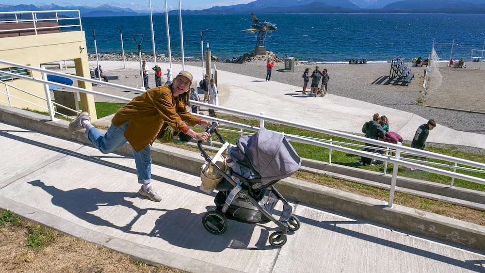Audrey Bergner with a stroller near Bariloche’s jet monument, Río Negro, Patagonia, Argentina Audrey Bergner pushes a stroller along the lakefront near Bariloche’s jet monument, with Lago Nahuel Huapi, distant mountains and a bright blue sky in Río Negro, Patagonia, Argentina.