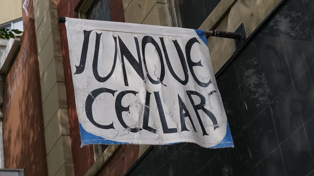 Junque Cellar storefront sign on Whyte Avenue in Old Strathcona, Edmonton, Alberta, Canada Weathered Junque Cellar fabric sign hanging outside a storefront on Whyte Avenue, representing the independent shopping scene in Old Strathcona, Edmonton, Alberta, Canada.