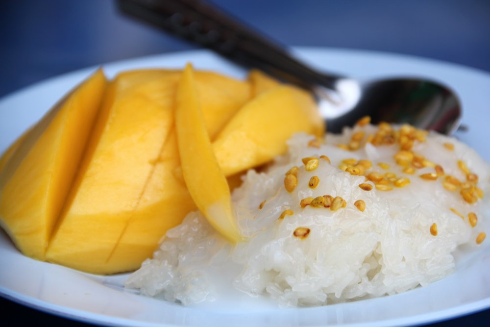 Khao Neow Mamuang (Sticky rice and mango) - One of the most prized Thai desserts is sweet sticky rice paired with ripe yellow mango and doused in coconut cream.