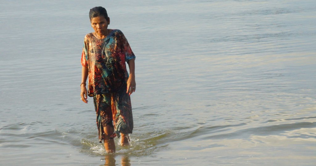 Khmer lady walking in the filthy waters of Sihanoukville, Cambodia