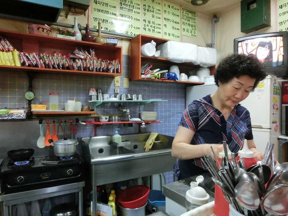 Korean lady cooking in traditional kitchen restaurant in Cheonan, Korea 