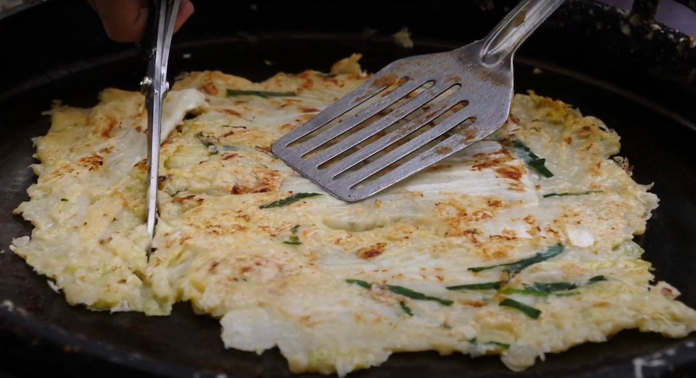 Korean pancake being cut into pieces at the Seomun Market in Daegu, Korea 