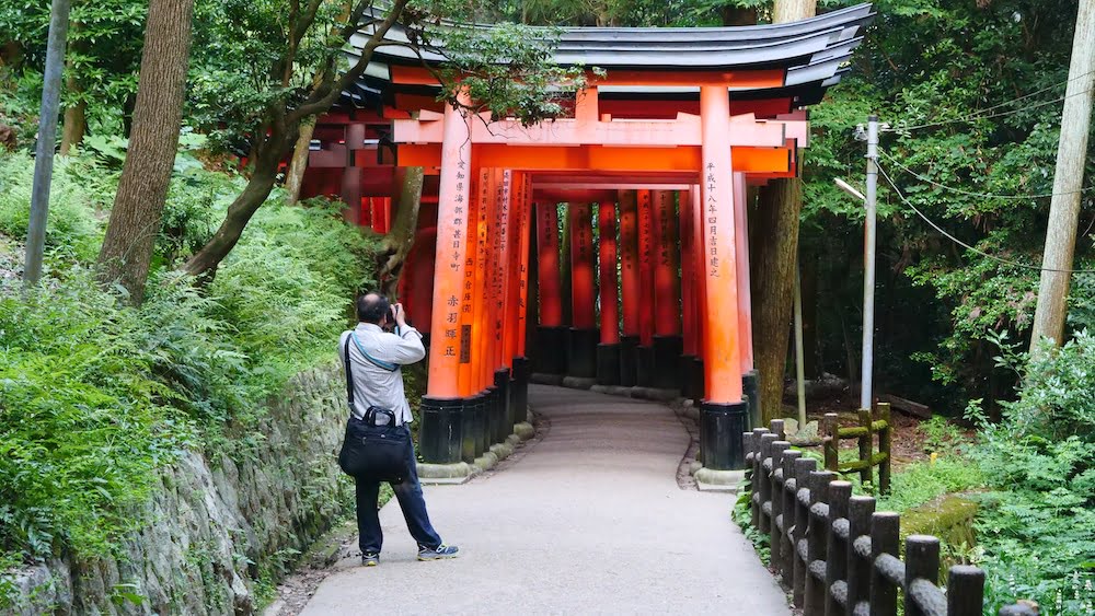 Photographer in Japan in Kyoto shooting the Tori Gates