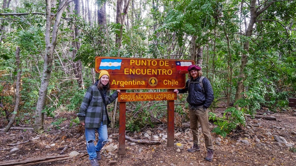 Frontera Argentina Chile en Lago Puelo Patagonia, Samuel Jeffery y Audrey Bergner en cartel marcando la dura realidad burocrática del cruce