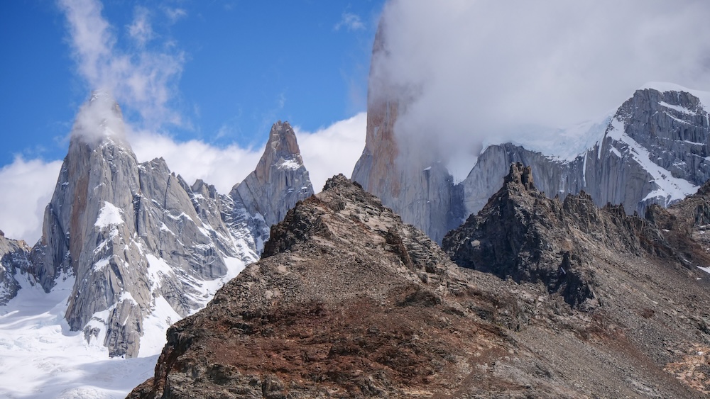 Laguna de los Tres trail in El Chaltén, Patagonia, showing Mount Fitz Roy’s jagged peaks wrapped in sudden clouds, illustrating how weather can shift quickly and turn calm hiking conditions into moody mountain drama.