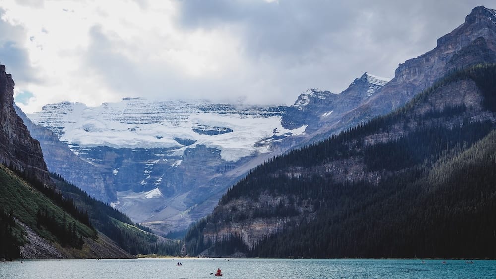 Lake Louise en el Parque Nacional Banff, Alberta, Canadá, con agua turquesa, glaciar y paisaje de las Montañas Rocosas Lake Louise en el Parque Nacional Banff, Alberta, Canadá, con agua turquesa, laderas boscosas y un amplio glaciar ocupando el valle bajo un cielo nublado.