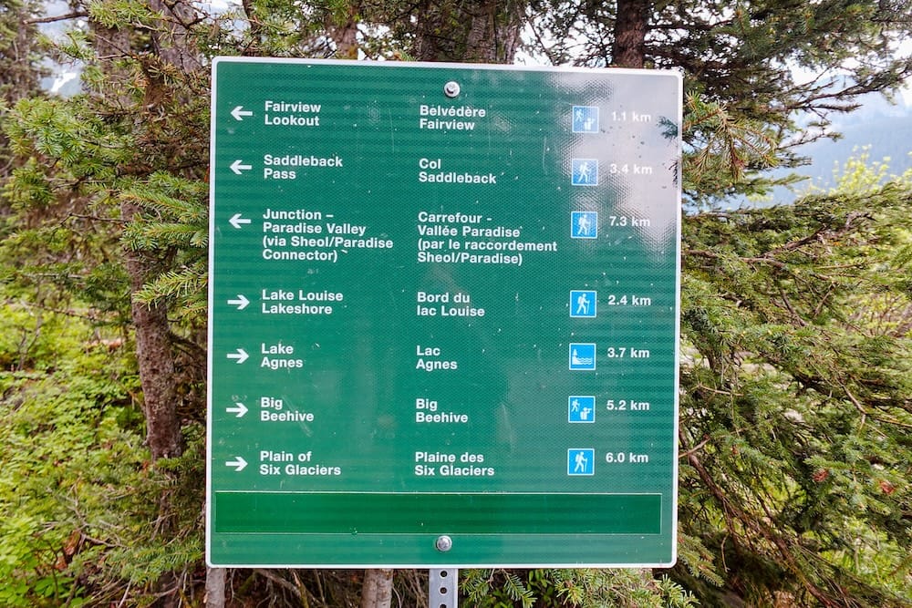 Hiking trail sign near Lake Louise in Banff National Park, Alberta, Canada, pointing toward Fairview Lookout, Lake Agnes, Big Beehive, Plain of Six Glaciers and other mountain routes.