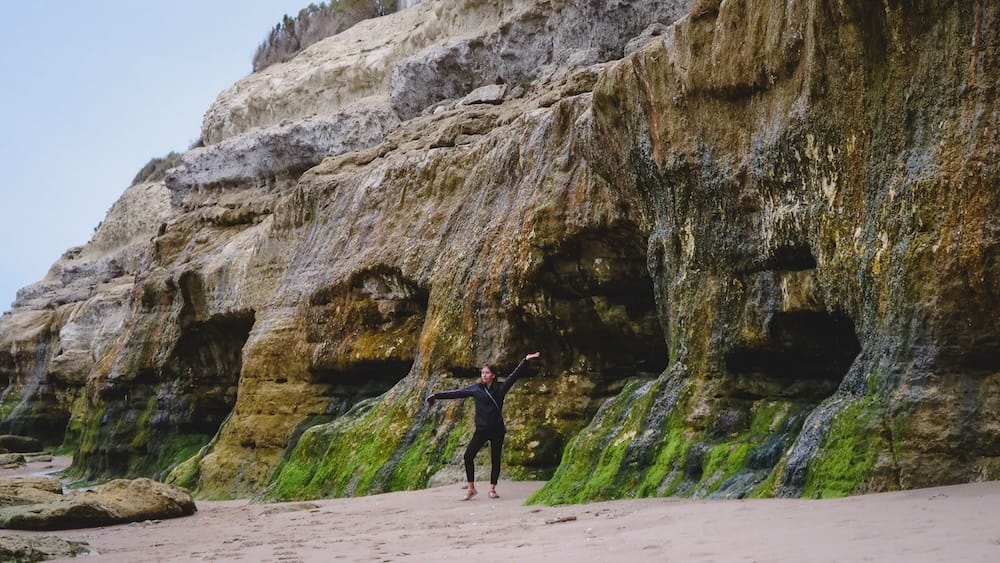 Audrey Bergner exploring eroded coastal cliffs at Las Grutas in Rio Negro Patagonia Argentina, highlighting unique beach landscapes shaped by ocean erosion along the Atlantic coast.
