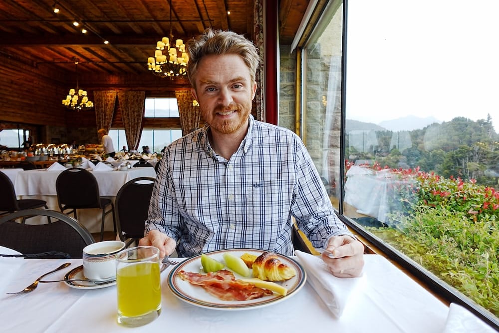 Samuel Jeffery having breakfast at Llao Llao Hotel in Bariloche, Río Negro, Patagonia, Argentina Samuel Jeffery sits beside a window at breakfast in Llao Llao Hotel, with coffee, juice, fruit, bacon and a croissant overlooking forested hills in Bariloche, Río Negro, Patagonia, Argentina.