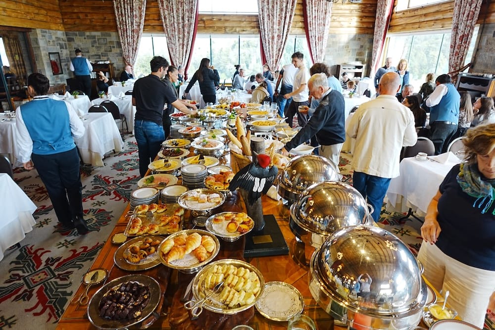 Lavish Breakfast Buffet Service in the Dining Room at Llao Llao Hotel, Bariloche, Patagonia, Argentina Lavish breakfast buffet at Llao Llao Hotel in Bariloche, Río Negro, Patagonia, Argentina, with pastries, hot dishes and fruit arranged in a grand dining room as guests and staff move around the tables.