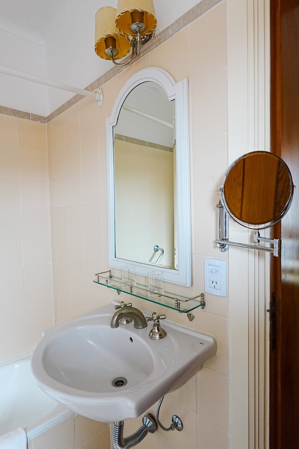 Bustillo Wing Bathroom Sink and Mirror, Llao Llao Hotel, Bariloche, Río Negro, Patagonia A pedestal sink beneath an arched mirror and a swivel-out magnifying mirror in a Bustillo Wing bathroom at Llao Llao Hotel, Bariloche, Río Negro, Argentine Patagonia.