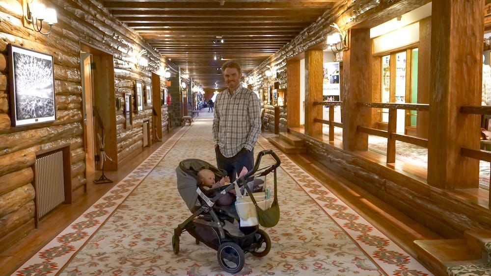 Samuel Jeffery pushes Aurelia Jeffery in a stroller through the long timber-lined grand hall of Llao Llao Hotel in Bariloche, Río Negro, Patagonia, Argentina.
